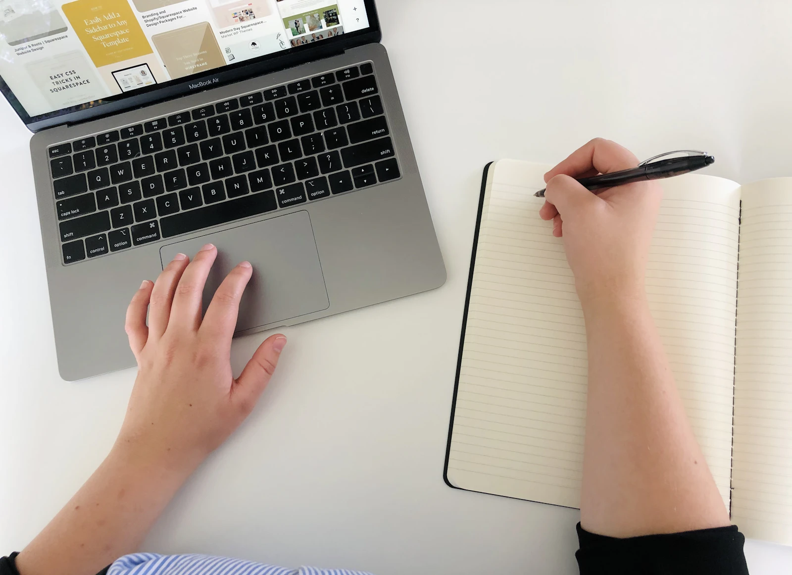 Osoba pracująca przy laptopie i zapisująca notatki